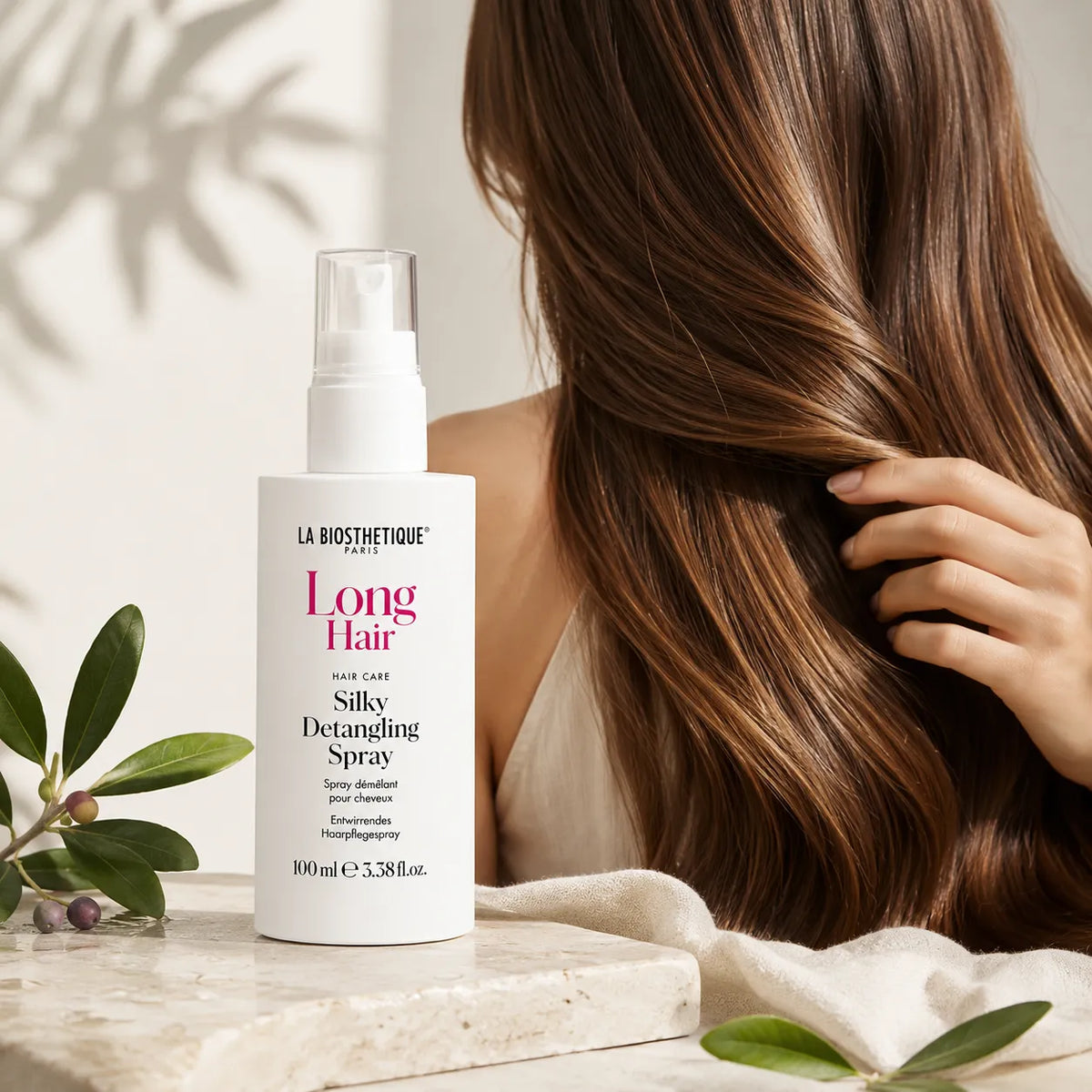 Spray démêlant cheveux longs La Biosthétique avec cheveux longs bruns et feuilles naturelles